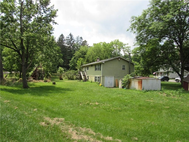 18 Mark Cir, Naples, NY 14512 - view of grassy yard with stairway and a storage shed