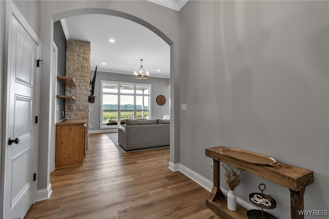 6993 Pine Lk, Pendleton, NY 14120 - hallway with ornamental molding, arched walkways, wood finished floors, a chandelier, and recessed lighting
