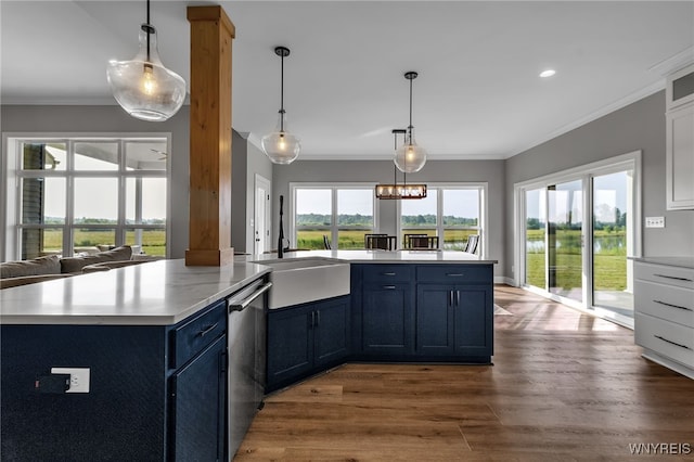 6993 Pine Lk, Pendleton, NY 14120 - kitchen with stainless steel dishwasher, ornamental molding, light countertops, blue cabinets, and wood finished floors
