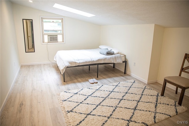 1346 Otisco Valley Rd, Otisco, NY 13110 - bedroom featuring a skylight, cooling unit, lofted ceiling, and wood finished floors