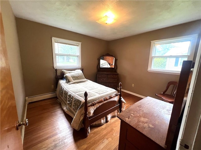 2 Maple Rd, Big Flats, NY 14845 - bedroom with a baseboard radiator, multiple windows, and light wood-type flooring