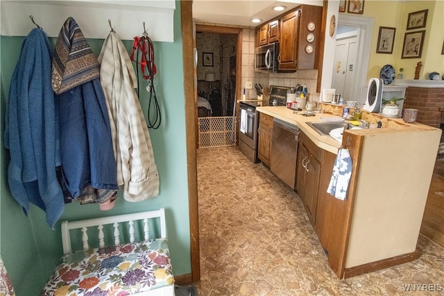 14 W Main St, Concord, NY 14141 - kitchen featuring stainless steel appliances, tasteful backsplash, brown cabinetry, light countertops, and a peninsula