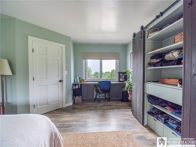 8800 Harmon Hill Rd, Pomfret, NY 14063 - bedroom with wood finished floors, an office area, and a barn door