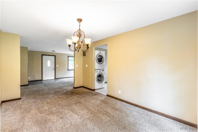 26 Farber Ln, Amherst, NY 14221 - empty room with stacked washing machine and dryer, carpet, and a chandelier