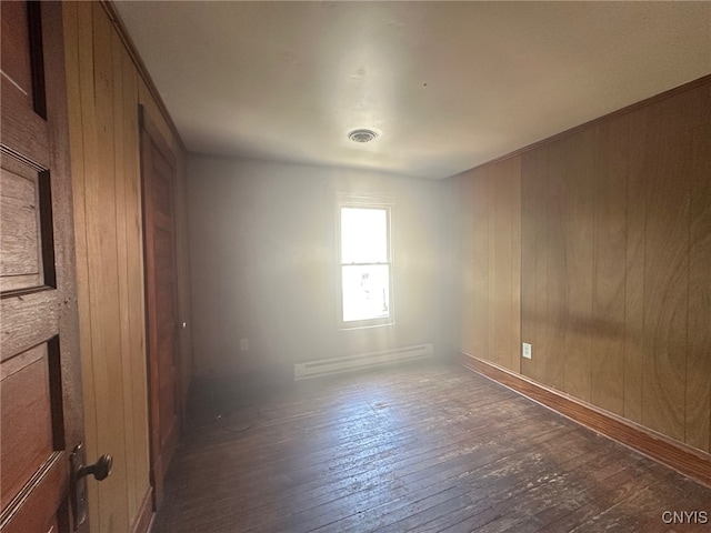 85 W Clark St, German Flatts, NY 13357 - unfurnished room with a baseboard radiator, hardwood / wood-style floors, and wood walls