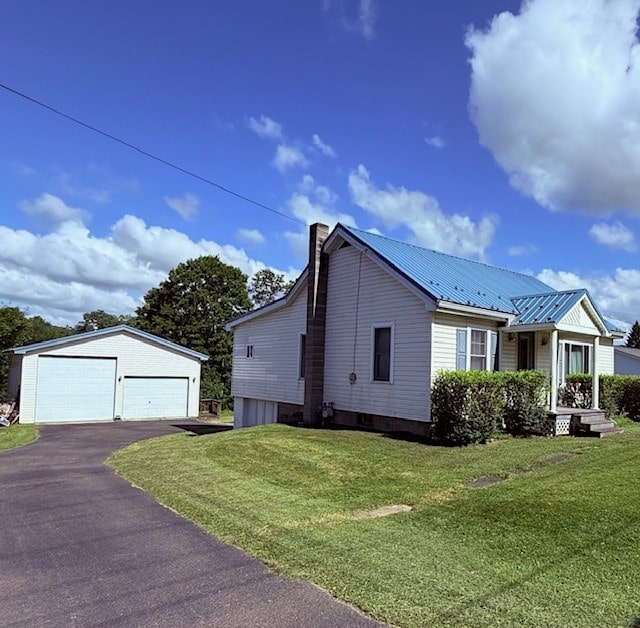 6113 Rte 46, Keating Town, PA 16749 - view of front of house featuring a detached garage, a chimney, an outdoor structure, a front lawn, and a metal roof
