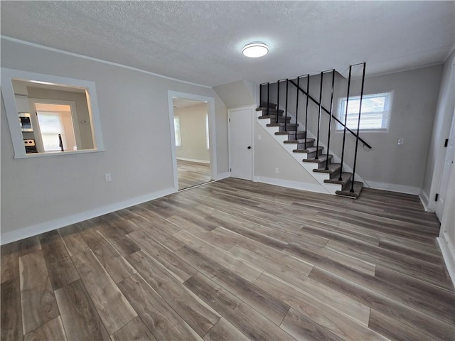 2381 Culver Rd, Irondequoit, NY 14609 - unfurnished living room with stairs, wood finished floors, and a textured ceiling