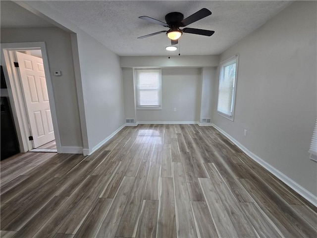 2381 Culver Rd, Irondequoit, NY 14609 - unfurnished room with wood finished floors, a ceiling fan, and a textured ceiling