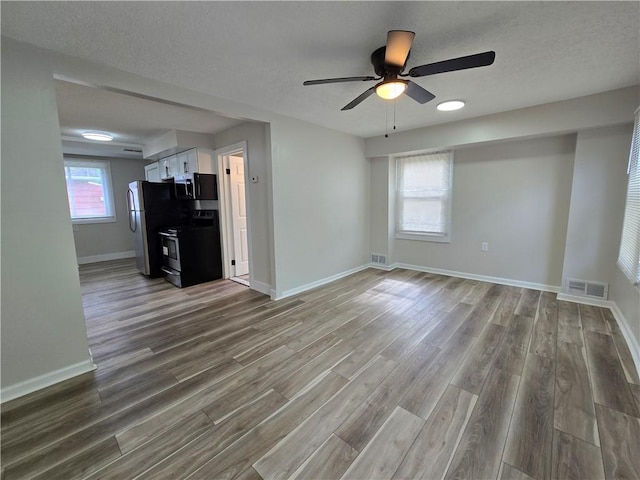 2381 Culver Rd, Irondequoit, NY 14609 - unfurnished living room featuring wood finished floors, ceiling fan, and a textured ceiling