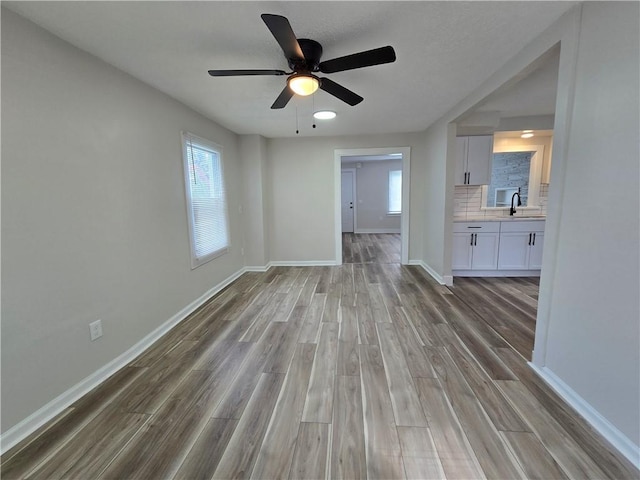 2381 Culver Rd, Irondequoit, NY 14609 - unfurnished living room with wood finished floors, healthy amount of natural light, and a ceiling fan
