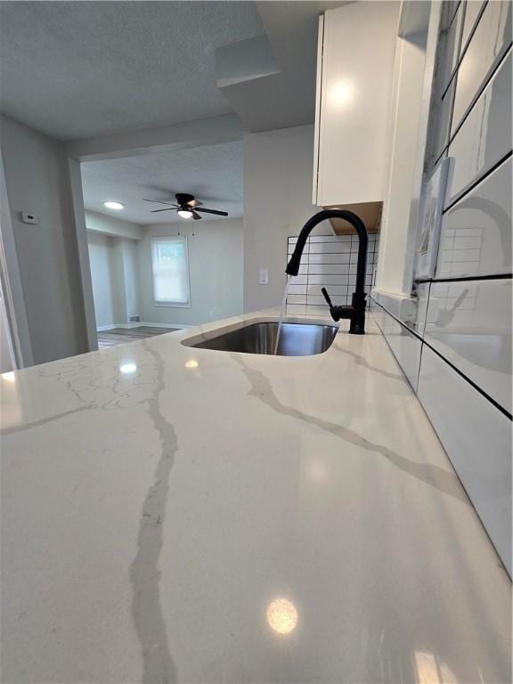 2381 Culver Rd, Irondequoit, NY 14609 - kitchen featuring light stone counters, white cabinets, and ceiling fan
