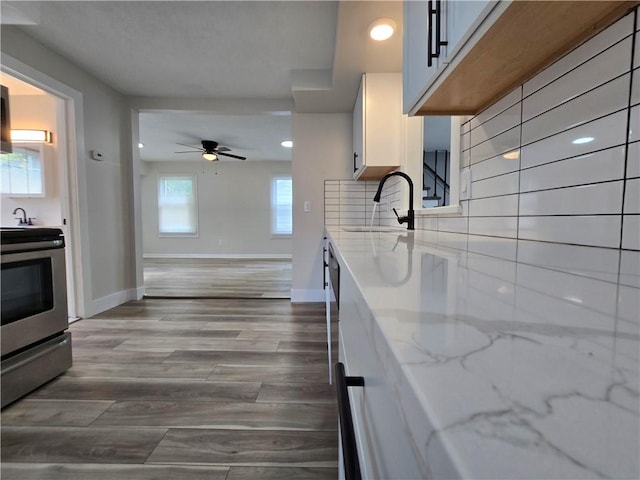 2381 Culver Rd, Irondequoit, NY 14609 - kitchen with stainless steel range with electric cooktop, light stone countertops, recessed lighting, a ceiling fan, and wood finished floors