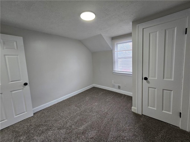2381 Culver Rd, Irondequoit, NY 14609 - additional living space with dark carpet, a textured ceiling, and vaulted ceiling