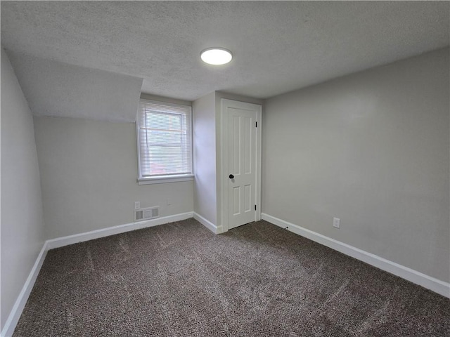 2381 Culver Rd, Irondequoit, NY 14609 - unfurnished bedroom with a textured ceiling and dark colored carpet
