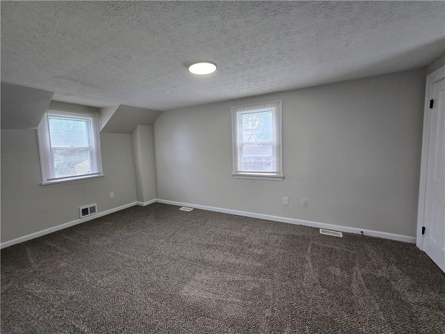 2381 Culver Rd, Irondequoit, NY 14609 - additional living space featuring a textured ceiling, dark carpet, and plenty of natural light