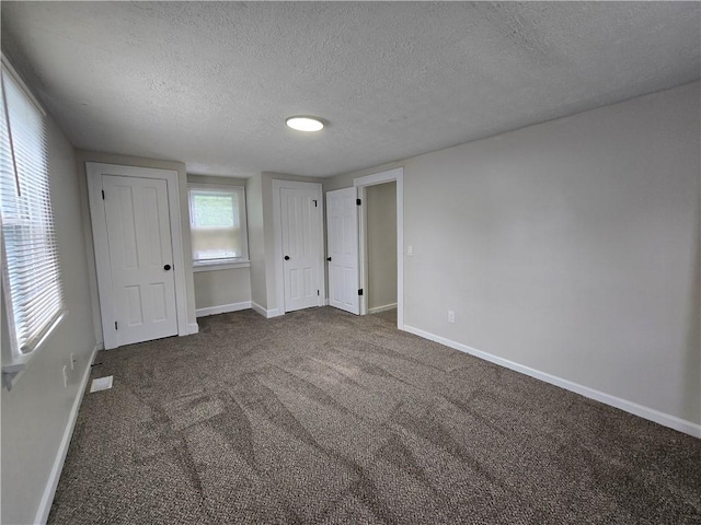 2381 Culver Rd, Irondequoit, NY 14609 - unfurnished bedroom featuring a textured ceiling and dark colored carpet