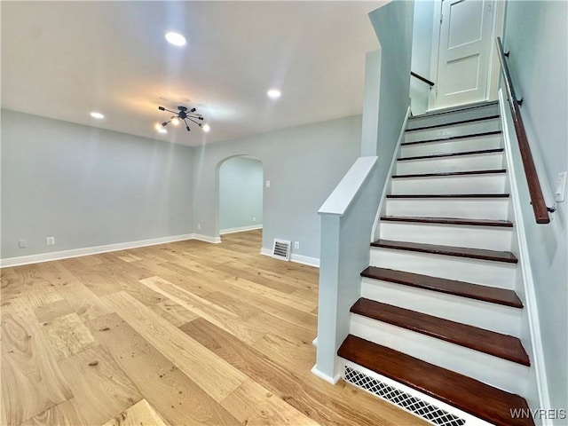 1433 Eggert Rd, Amherst, NY 14226 - stairway featuring arched walkways, wood finished floors, and recessed lighting