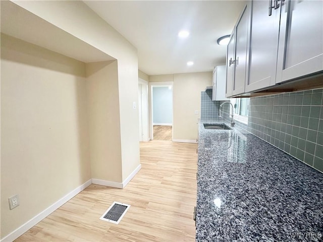 1433 Eggert Rd, Amherst, NY 14226 - kitchen featuring decorative backsplash, dark stone counters, recessed lighting, light wood-type flooring, and gray cabinetry