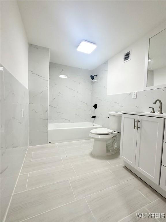 1433 Eggert Rd, Amherst, NY 14226 - full bathroom with vanity, tile walls, and bathtub / shower combination