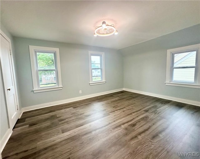 1433 Eggert Rd, Amherst, NY 14226 - unfurnished bedroom featuring multiple windows, dark wood-style flooring, and vaulted ceiling
