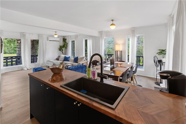 2064 County Highway 8, Roxbury, NY 12421 - kitchen featuring dark cabinets, open floor plan, wood counters, light wood-style flooring, and a wall mounted air conditioner
