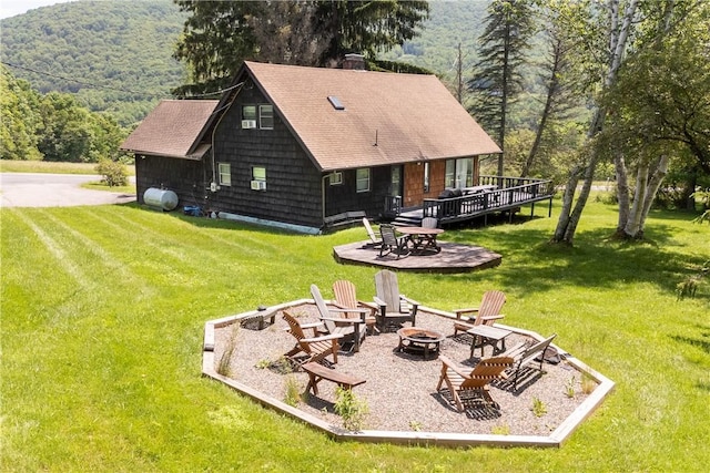 2064 County Highway 8, Roxbury, NY 12421 - back of property featuring a fire pit, a wooden deck, a lawn, and a wooded view