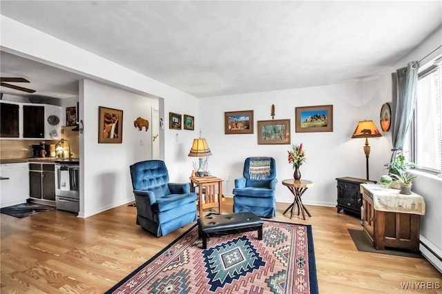 51 S 86th St Unit 10B, Niagara Falls, NY 14304 - living area with light wood-style flooring, a wood stove, a baseboard radiator, and a ceiling fan