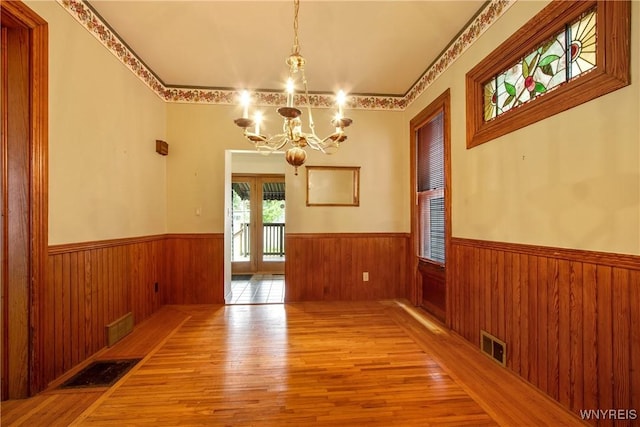 499 Breckenridge St, Buffalo, NY 14213 - unfurnished dining area with a chandelier, a wainscoted wall, wood finished floors, and wood walls