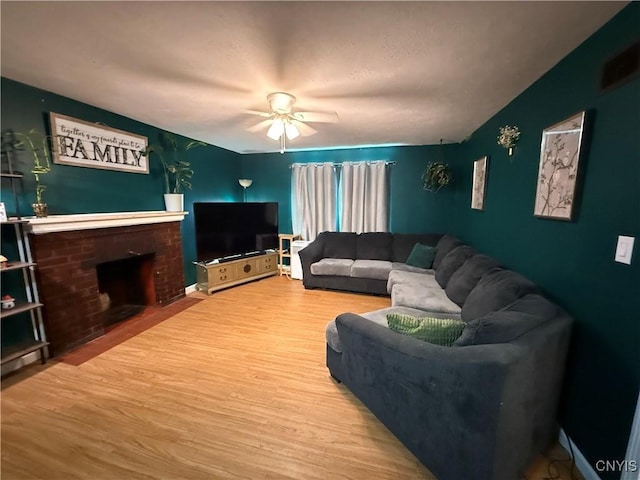35381 State Route 3, Wilna, NY 13619 - living room with wood finished floors, a fireplace, and ceiling fan
