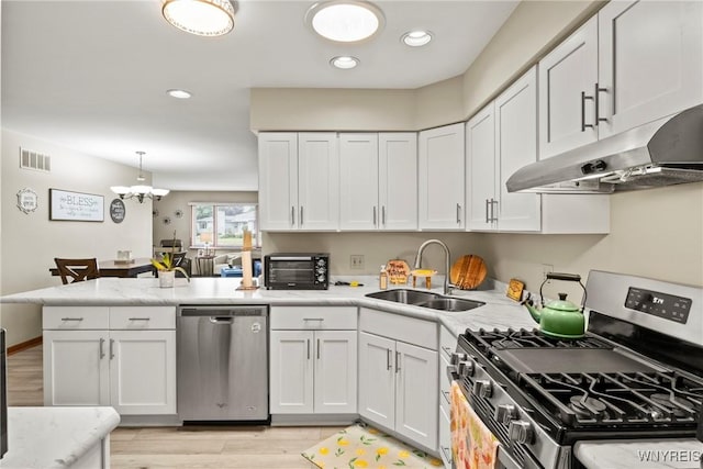 5861 Goodrich Rd Unit 6C, Clarence, NY 14032 - kitchen featuring appliances with stainless steel finishes, under cabinet range hood, a peninsula, light wood-style floors, and white cabinetry