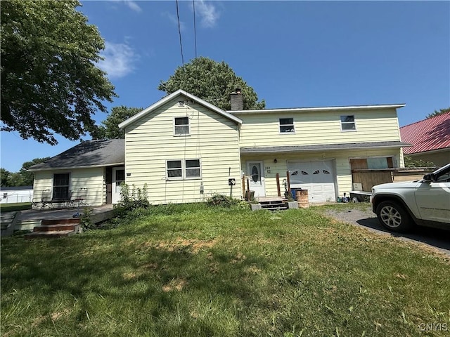 352 S Real St, Cape Vincent, NY 13618 - back of house with a yard, a chimney, an attached garage, and driveway