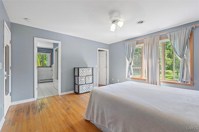6924 Todd Way, Salina, NY 13088 - bedroom featuring a baseboard heating unit, wood-type flooring, ensuite bathroom, and ceiling fan