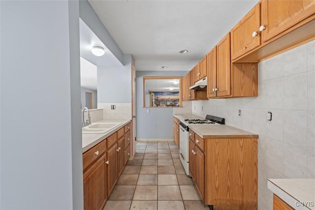 6924 Todd Way, Salina, NY 13088 - kitchen featuring white gas range, light countertops, tasteful backsplash, under cabinet range hood, and brown cabinets