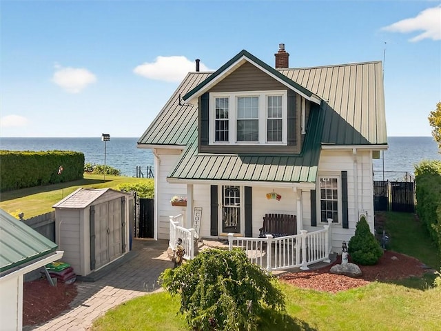 5631 W Blf, Newfane, NY 14126 - view of front facade featuring a storage unit, a water view, covered porch, and a chimney