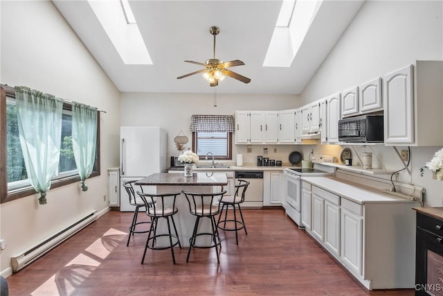 229 Gillespie Ave, Camillus, NY 13219 - kitchen with a skylight, white appliances, a baseboard radiator, under cabinet range hood, and high vaulted ceiling
