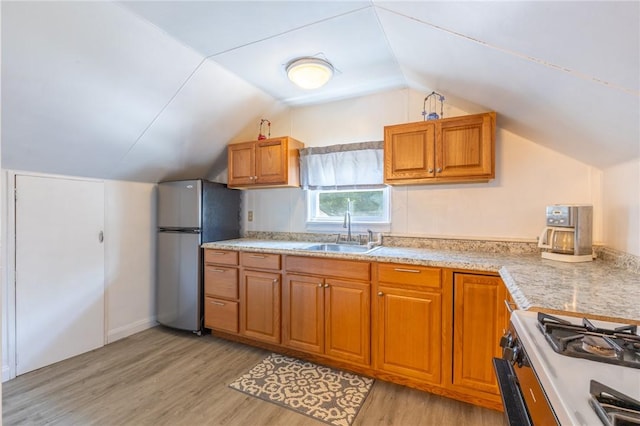 82 Barnard St, Greece, NY 14616 - kitchen featuring freestanding refrigerator, light wood-style floors, brown cabinetry, lofted ceiling, and light countertops