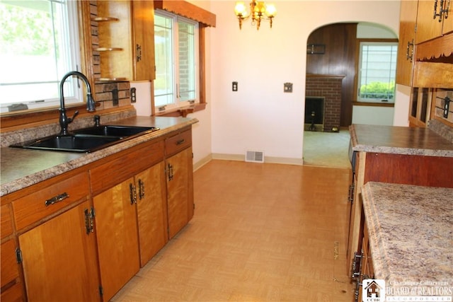 410 Chestnut St, Pomfret, NY 14063 - kitchen featuring light flooring, a fireplace, brown cabinets, light countertops, and arched walkways