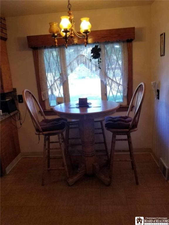 410 Chestnut St, Pomfret, NY 14063 - dining space featuring a chandelier and baseboards