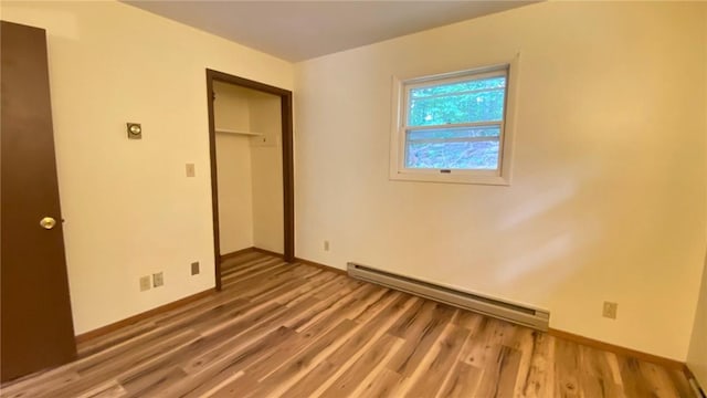 1221 Garden Ln, Middlesex, NY 14507 - unfurnished bedroom featuring a baseboard radiator, wood finished floors, and a closet