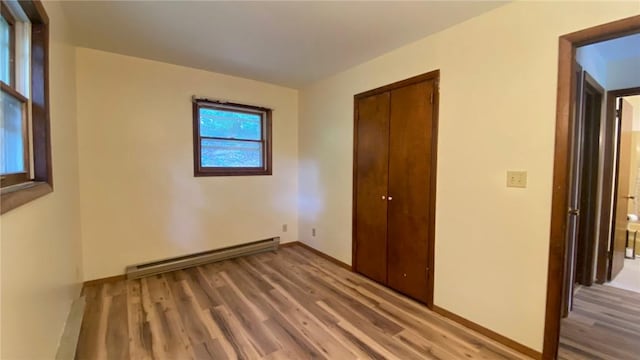 1221 Garden Ln, Middlesex, NY 14507 - unfurnished bedroom featuring baseboard heating, light wood-type flooring, and a closet