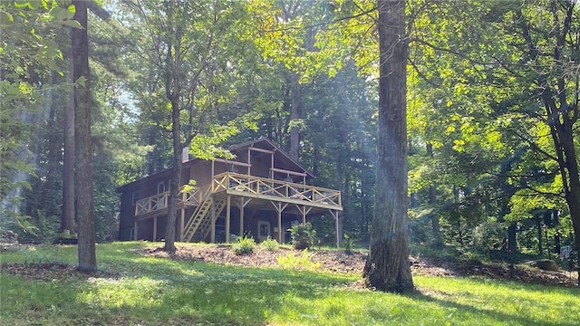 1221 Garden Ln, Middlesex, NY 14507 - back of property with a wooden deck, a forest view, stairway, and a lawn
