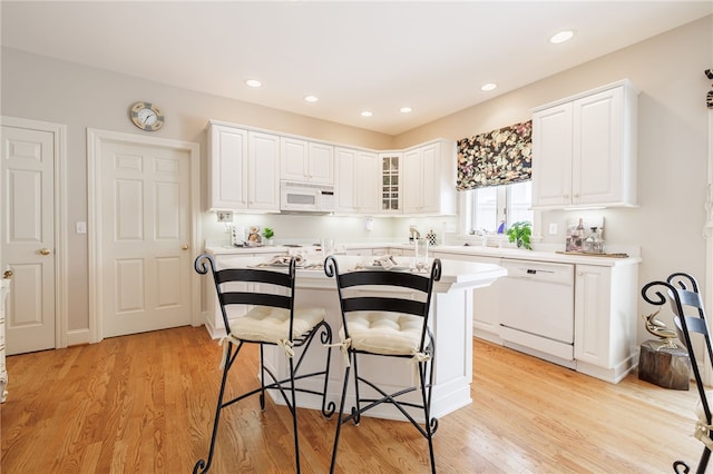 10 Bristol View Dr, Perinton, NY 14450 - kitchen featuring white appliances, a breakfast bar, white cabinets, light countertops, and glass insert cabinets