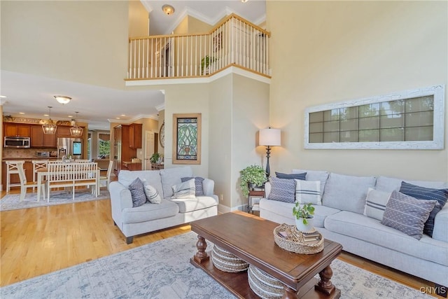 1002 Oreste St, Camillus, NY 13031 - living room featuring light wood finished floors, crown molding, a high ceiling, and recessed lighting