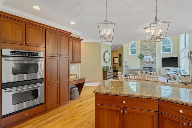 1002 Oreste St, Camillus, NY 13031 - kitchen featuring stainless steel double oven, a chandelier, ornamental molding, light wood-type flooring, and decorative light fixtures