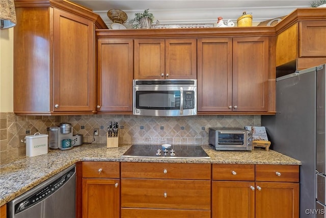 1002 Oreste St, Camillus, NY 13031 - kitchen featuring stainless steel appliances, backsplash, light stone countertops, and brown cabinetry