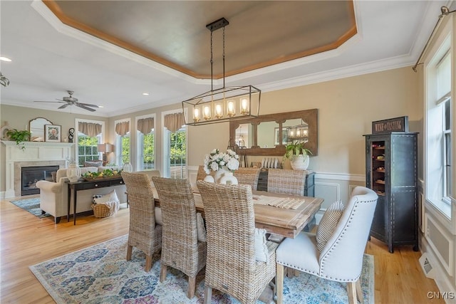 1002 Oreste St, Camillus, NY 13031 - dining space featuring a raised ceiling, light wood-type flooring, crown molding, a chandelier, and a wainscoted wall