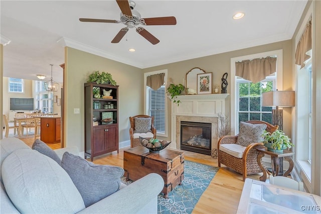 1002 Oreste St, Camillus, NY 13031 - living room with light wood-style flooring, a premium fireplace, a ceiling fan, ornamental molding, and recessed lighting