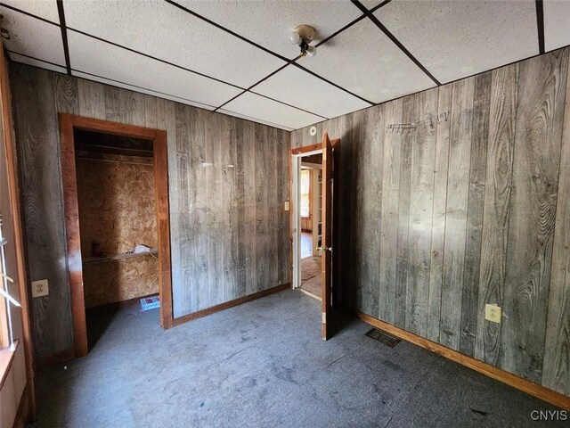 312 Richmond Ave Unit 314, Syracuse, NY 13204 - unfurnished bedroom featuring a paneled ceiling, wooden walls, and carpet flooring