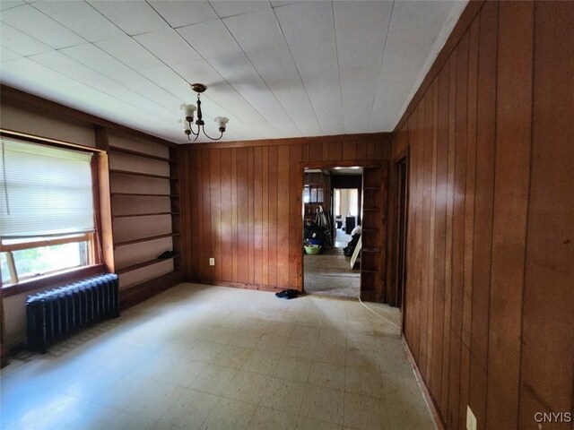 312 Richmond Ave Unit 314, Syracuse, NY 13204 - unfurnished dining area featuring radiator, wood walls, a chandelier, and light floors