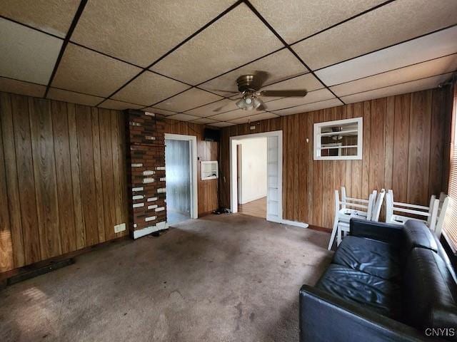 312 Richmond Ave Unit 314, Syracuse, NY 13204 - carpeted living area featuring a paneled ceiling, wooden walls, and ceiling fan